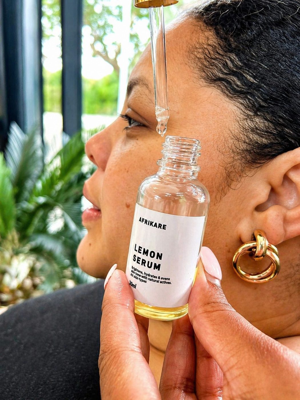 A woman applying Afrikare Lemon Serum with a dropper